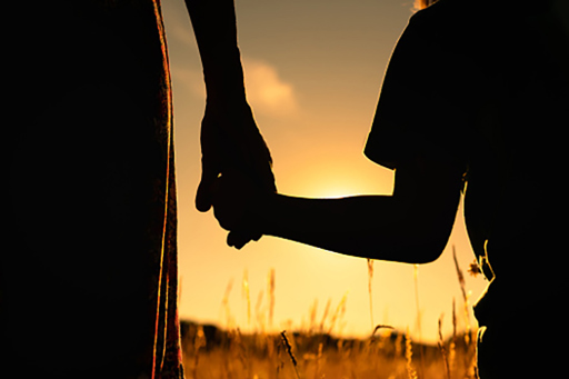 Parent holding child hand silhouette